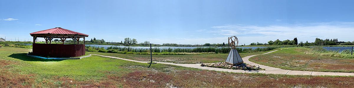 Gazebo and walking path in a park in Holden, Alberta, overlooking a pond